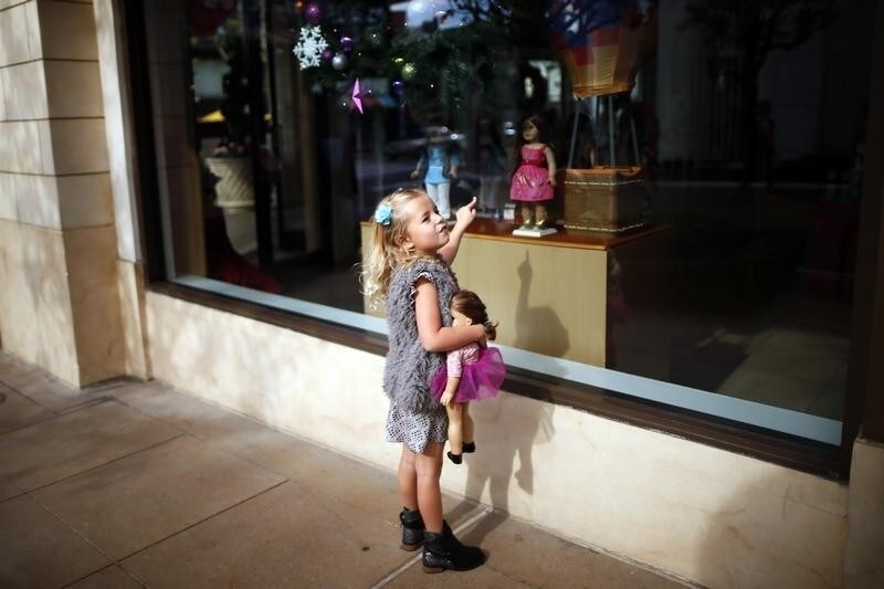 Charli Crosby, 5, points to a doll in the window of an American Girl store at The Grove mall in Los Angeles November 26, 2013. This year, Black Friday starts earlier than ever, with some retailers opening early on Thanksgiving evening. About 140 million people were expected to shop over the four-day weekend, according to the National Retail Federation. REUTERS/Lucy Nicholson (UNITED STATES - Tags: BUSINESS) - RTX15UG2