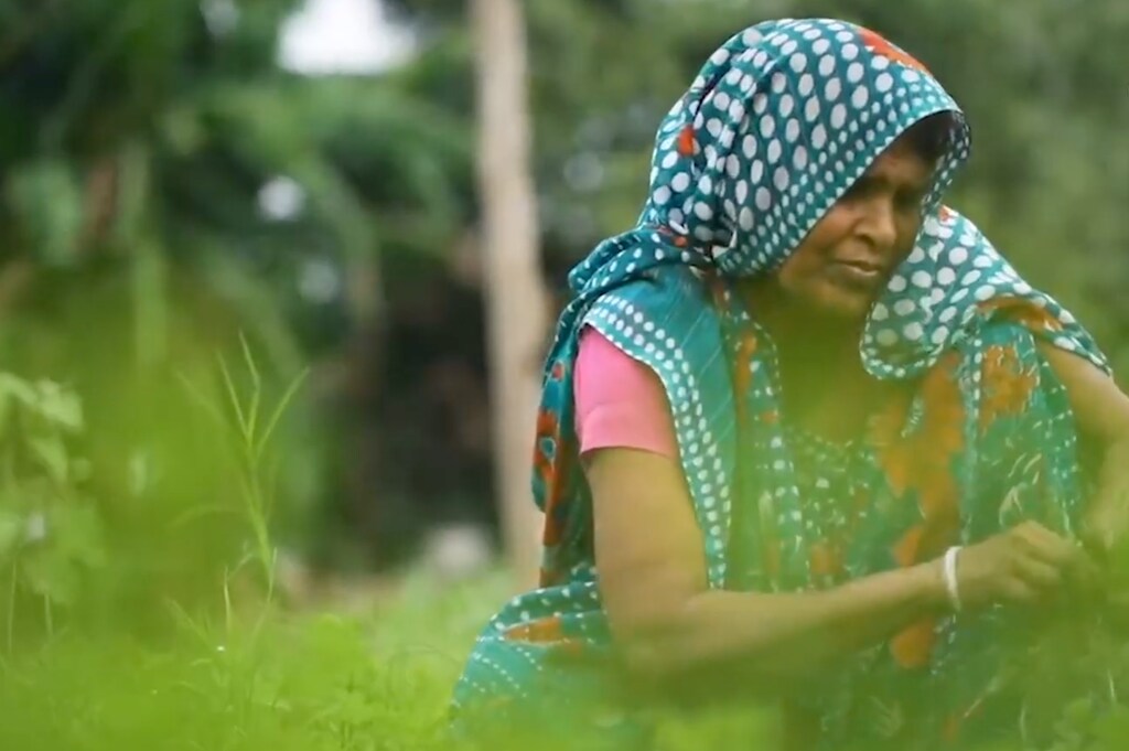 The Mastercard Center for Inclusive Growth makes impact data science a top priority. Pictured here: A woman working in an open field during the day.
