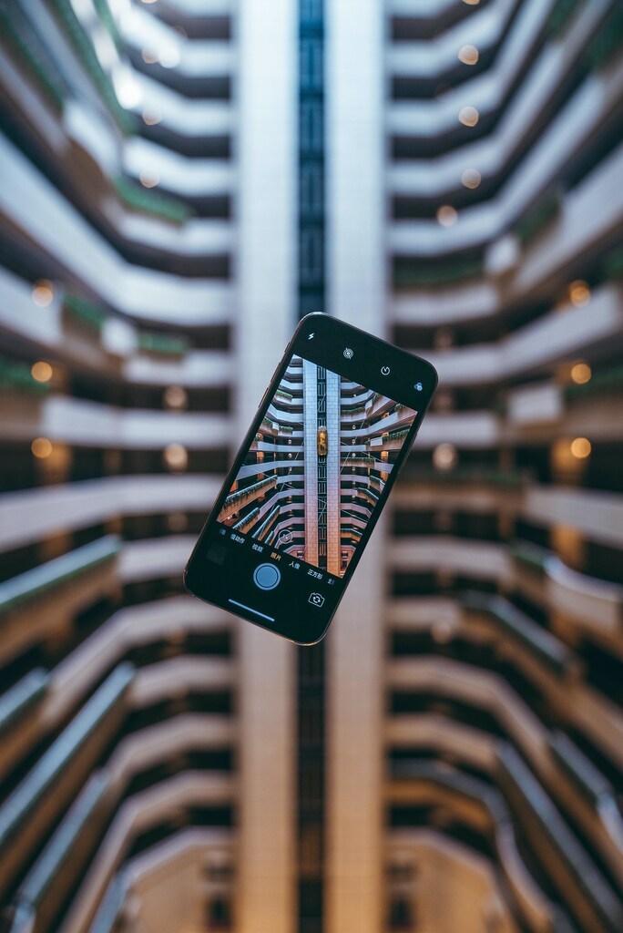 Smart phone suspended in the air with camera capture open on building: Digitalization could enable $100 trillion of additional value for the world economy by 2025.