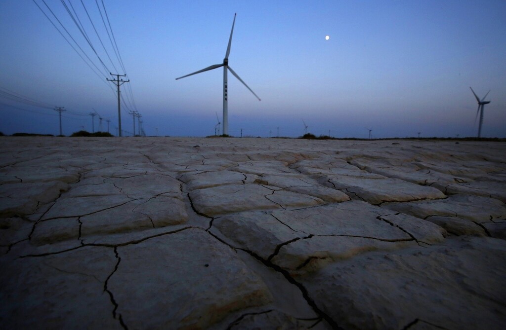 Cracked earth marks a dried-up area near a wind turbine used to generate electricity at a wind farm in Guazhou, 950km (590 miles) northwest of Lanzhou, Gansu Province September 15, 2013.