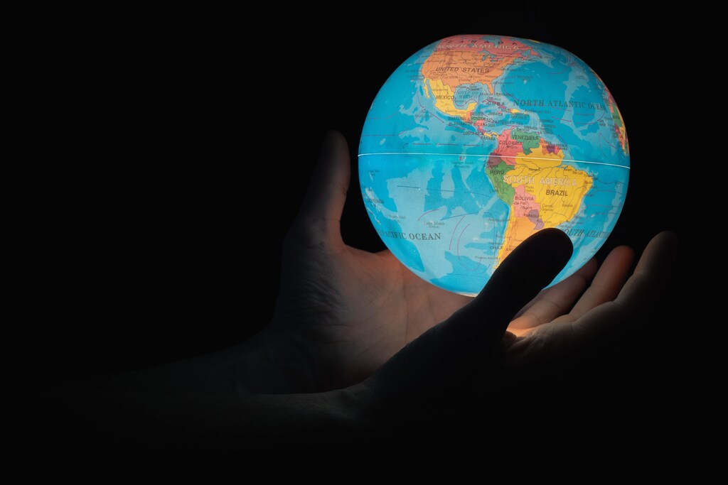 an image of human hands holding a globe