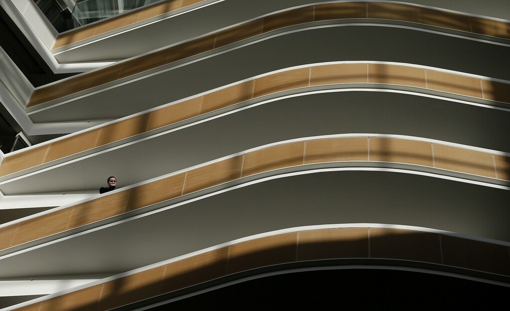 A worker watches from a balcony in the atrium of 1 Angel Square, the new headquarters of the Co-operative group in Manchester, northern England November 14, 2013. The company's new head office has been declared the most environmentally-friendly building in the world according to the British research establishment environmental assessment method. REUTERS/Phil Noble (BRITAIN - Tags: ENVIRONMENT BUSINESS REAL ESTATE) - RTX15DIL