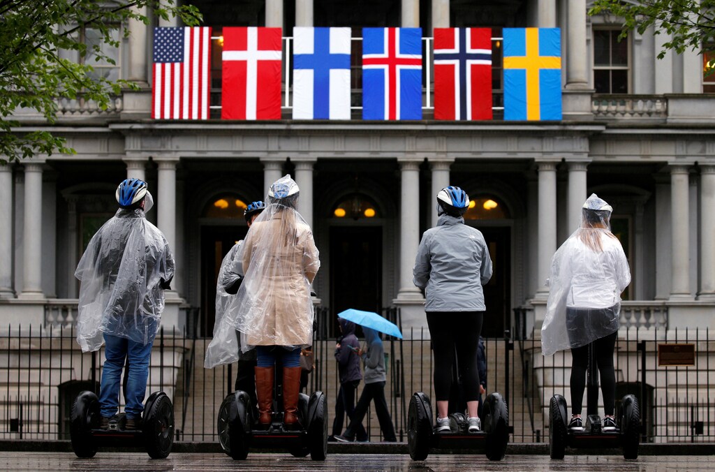 A segway tour stops in front of flags of the Nordic nations hanging from the Eisenhower Executive Office Building beside the White House in Washington, May 11, 2016. On Friday, U.S. President Barack Obama will host the leaders of Denmark, Finland, Iceland, Norway and Sweden for a U.S.-Nordic Leaders Summit. REUTERS/Kevin Lamarque - S1BETDMHQOAA