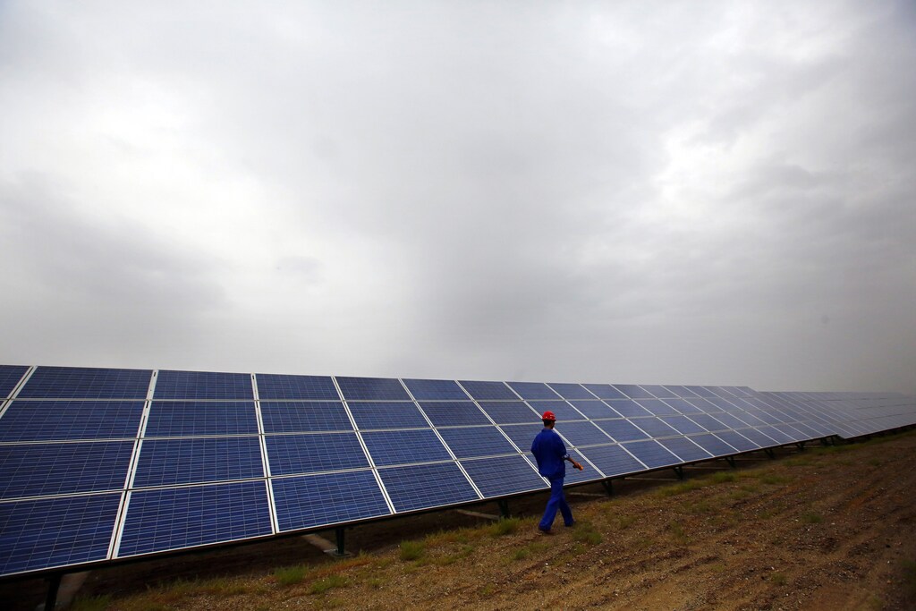 A worker inspects solar panels at a solar farm in Dunhuang, 950km (590 miles) northwest of Lanzhou, Gansu Province September 15, 2013. China is pumping investment into wind power, which is more cost-competitive than solar energy and partly able to compete with coal and gas. China is the world's biggest producer of CO2 emissions, but is also the world's leading generator of renewable electricity. Environmental issues will be under the spotlight during a working group of the Intergovernmental Panel on Climate Change, which will meet in Stockholm from September 23-26. REUTERS/Carlos Barria (CHINA - Tags: ENERGY BUSINESS ENVIRONMENT) - GM1E99M17XD01