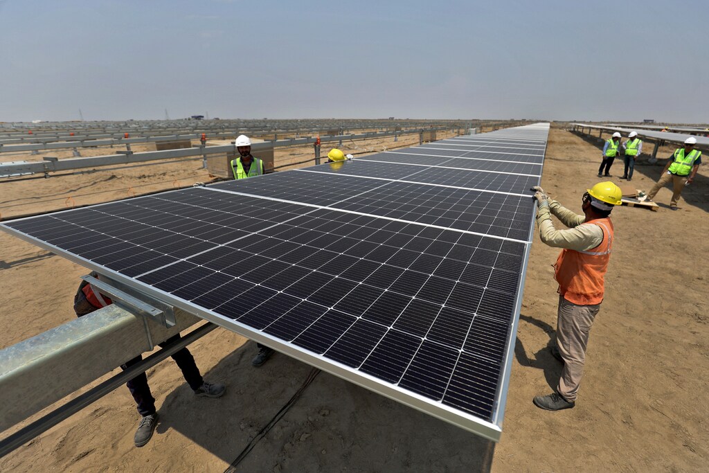 Los trabajadores instalan paneles solares en el Parque de Energía Renovable Khavda de Adani Green Energy Ltd (AGEL) en Khavda, India, el 12 de abril de 2024. REUTERS/Amit Dave