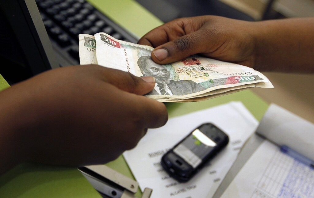 A customer conducts a mobile money transfer, known as M-Pesa, inside the Safaricom mobile phone care centre in the central business district of Kenya's capital Nairobi July 15, 2013. To match Insight AFRICA-MOBILEMONEY/ Picture taken July 15, 2013.