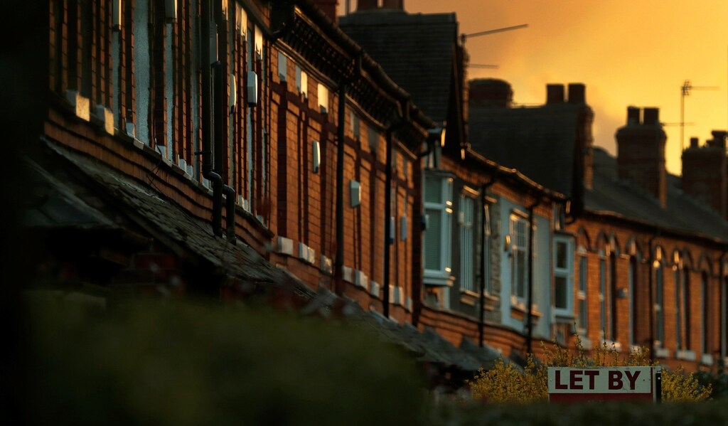 An estate agents sign for a house to rent is seen in front of a row of terraced houses in Altrincham northern England, April 16, 2016.