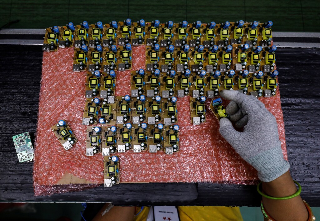 A worker arranges battery charger circuit boards at a mobile phone battery manufacturing plant in Noida, India, October 12, 2018. Picture taken October 12, 2018. REUTERS/Anushree Fadnavis - RC118A511050