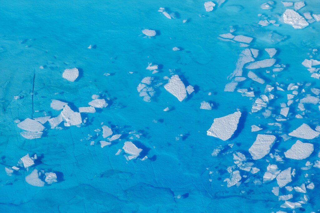 image of chunks of ice floating inside of meltwater pools on top of the Helheim glacier near Tasiilaq, Greenland