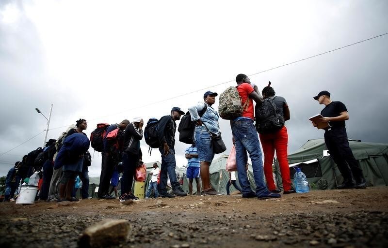 An official of migration gives instructions to a group of Haitian and Africans migrants stranded in Costa Rica, who arrived at a makeshift camp at the border between Costa Rica and Nicaragua, in La Cruz, Costa Rica, December 20, 2016. Picture taken December 20, 2016. REUTERS/Juan Carlos Ulate - RTX2W2TC