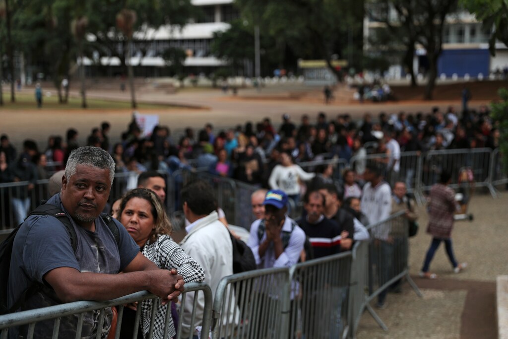Unemployed people line up to fill out applications while looking for job opportunities in downtown Sao Paulo, Brazil.