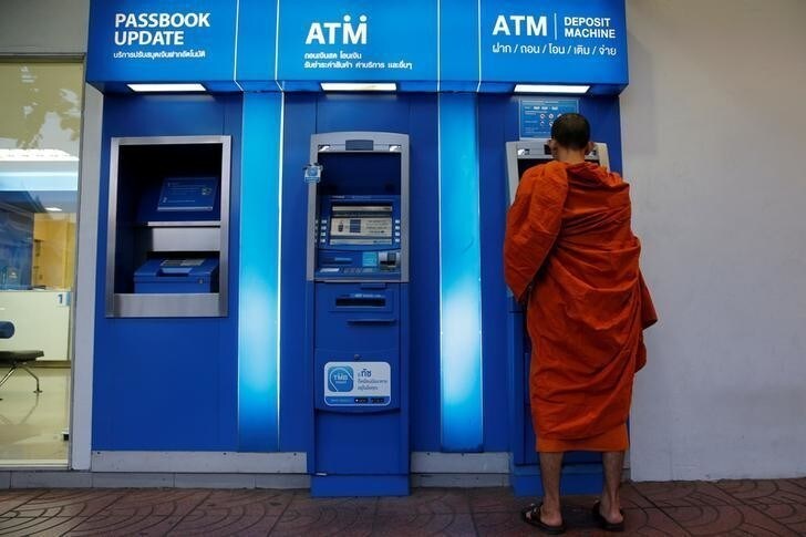 A Buddhist monk uses an ATM in Bangkok, Thailand, May 3, 2016. REUTERS/Jorge Silva