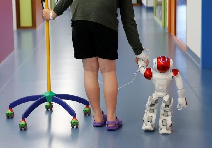 Belgian Ian Frejean, 11, walks with "Zora" the robot, a humanoid robot designed to entertain patients and to support care providers, at AZ Damiaan hospital in Ostend, Belgium June 16, 2016. REUTERS/Francois Lenoir
