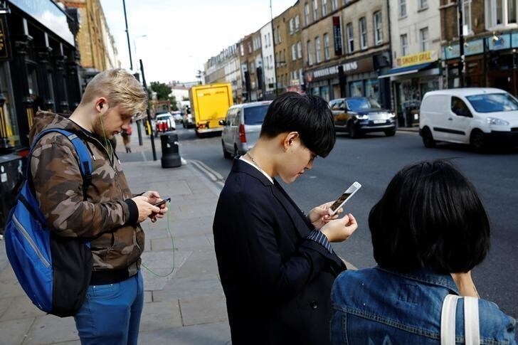 Pedestrians look at their mobile phones near Brick Lane in London, Britain October 5, 2016. REUTERS/Stefan Wermuth SEARCH "WERMUTH PHONES" FOR THIS STORY. SEARCH "THE WIDER IMAGE" FOR ALL STORIES.