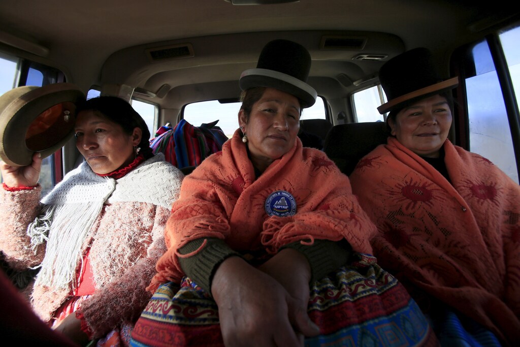 Aymara indigenous women Bertha Vedia (L), Dora Magueno (C) and Lidia Huayllas sit in a car in El Alto, Bolivia, April 6, 2016. Two years ago, about a dozen Aymara indigenous women, aged 42 to 50, who worked as porters and cooks for mountaineers at base camps and mountain climbing refuges on the steep, glacial slopes of Huayna Potosi, an Andean peak outside La Paz, Bolivia, put on crampons under their wide traditional skirts and started to do their own climbing. REUTERS/David Mercado SEARCH "CHOLITA CLIMBERS" FOR THIS STORY. SEARCH "THE WIDER IMAGE" FOR ALL STORIES - RTX2B1HG