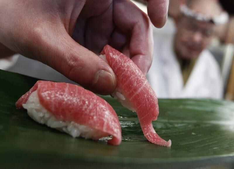 A sushi chef serves sushi of high-quality fatty Atlantic bluefin tuna or "o-toro sushi nigiri" at a sushi restaurant in Tokyo March 18, 2010. The outcome of a drive to ban trade in Atlantic bluefin tuna, prized as a delicacy in Japan, is too close to call before U.N. talks which started last Saturday that will test the world's ability to protect dwindling fish stocks. The 175-nation meeting of the Convention on International Trade in Endangered Species (CITES) in Doha, Qatar, from March 13-25, will vote on about 40 proposals for regulating trade in species including sharks, corals, elephants and polar bears. REUTERS/Issei Kato (JAPAN - Tags: POLITICS ENVIRONMENT IMAGES OF THE DAY FOOD) - GF2E63I0T0O01