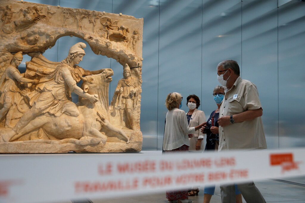 Los visitantes, con máscaras protectoras, caminan entre las esculturas de la "Galerie du Temps" (Galería del Tiempo) del museo del Louvre Lens durante su reapertura en Lens, ya que los museos franceses reabren con medidas de seguridad tras el brote de la enfermedad coronavirus (COVID-19) en Francia, el 3 de junio de 2020.