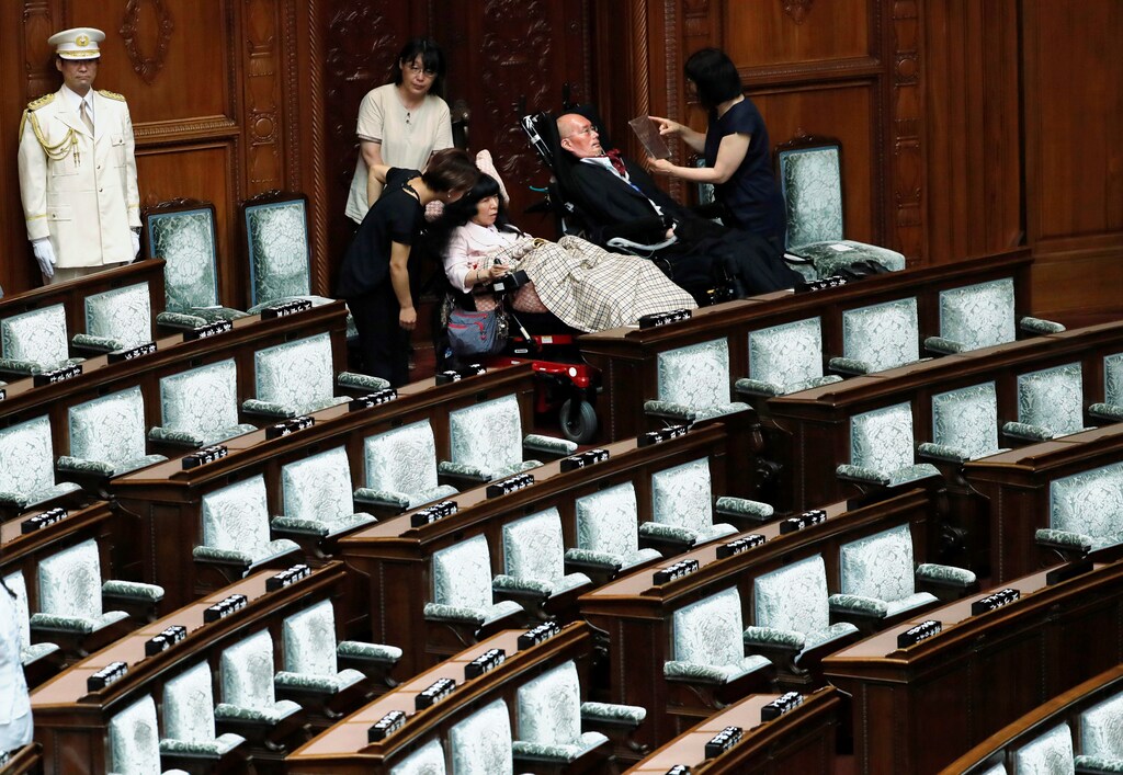 Reiwa Shinsengumi party's disabled lawmaker Yasuhiko Funago, who has amyotrophic lateral sclerosis (ALS), and Eiko Kimura, who has cerebral palsy, prepare to leave the hall after attending the opening of an extraordinary session of parliament in Tokyo, Japan, August 1, 2019. REUTERS/Kim Kyung-Hoon - RC11BD237100