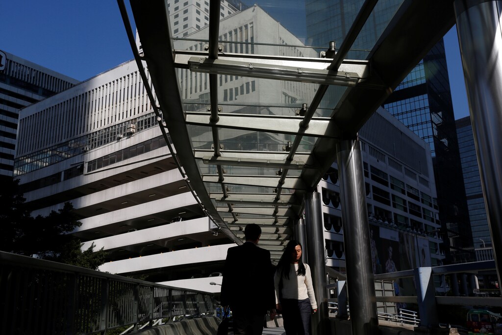 People walk on a footbridge in front of a multi-story car park, which will be auctioned with value as high as $2.2 billion in the first quarter of 2017, the first sale of commercial land in the Central business district in more than 20 years, in Hong Kong, China January 27, 2017. REUTERS/Bobby Yip - RTSXM0I