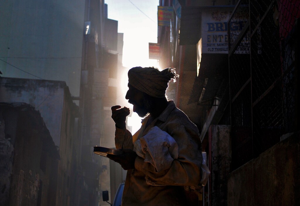 A homeless man eats his breakfast on a street in Bengaluru, India, November 25, 2016. REUTERS/Abhishek N. Chinnappa TPX IMAGES OF THE DAY - RC16F0020960