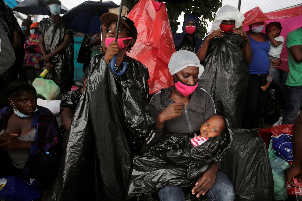 Migrants from Africa, Cuba and Haiti, who are stranded in Honduras after borders were closed due to the coronavirus (COVID-19) pandemic, shield from the rain during their trek northward in an attempt to reach the U.S., in Tegucigalpa, Honduras June 3, 2020. REUTERS/Jorge Cabrera - RC2Y1H9B08ZD