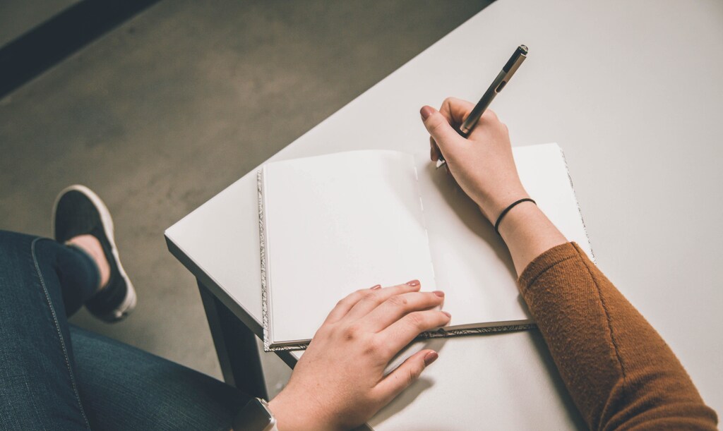 A person doing creative writing in their journal.
