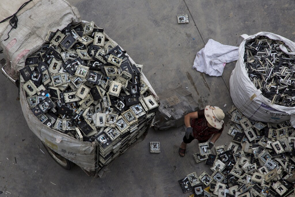 A worker distributes electronic waste at a government managed recycling centre at the township of Guiyu in China's southern Guangdong province June 10, 2015. The town of Guiyu in the economic powerhouse of Guangdong province in China has long been known as one of the worlds largest electronic waste dump sites. At its peak, some 5,000 workshops in the village recycle 15,000 tonnes of waste daily including hard drives, mobile phones, computer screens and computers shipped in from across the world. Many of the workers, however, work in poorly ventilated workshops with little protective gear, prying open discarded electronics with their bare hands. Plastic circuit boards are also melted down to salvage bits of valuable metals such as gold, copper and aluminum. As a result, large amounts of pollutants, heavy metals and chemicals are released into the rivers nearby, severely contaminating local water supplies, devastating farm harvests and damaging the health of residents. The stench of burnt plastic envelops the small town of Guiyu, while some rivers are black with industrial effluent. According to research conducted by Southern Chinas Shantou University, Guiyus air and water is heavily contaminated by toxic metal particles. As a result, children living there have abnormally high levels of lead in their blood, the study found. While most of the e-waste was once imported into China and processed in Guiyu, much more of the discarded e-waste now comes from within China as the country grows in affluence. China now produces 6.1 million metric tonnes of e-waste a year, according to the Ministry of Industry and Information Technology, second only to the U.S with 7.2 million tonne