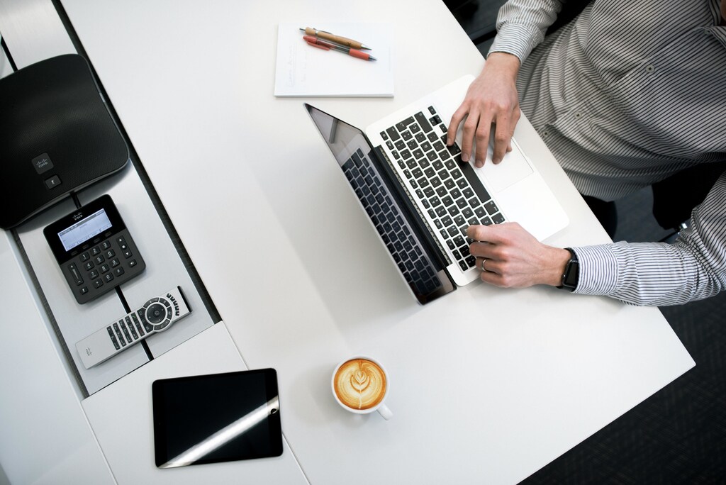 Man typing on laptop at desk.