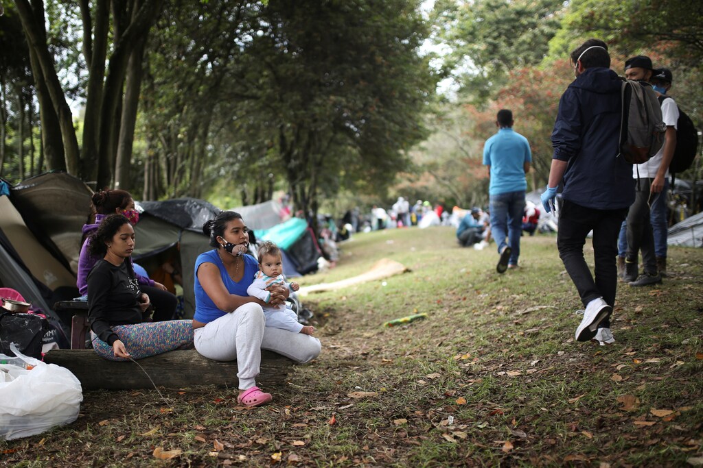 A Venezuelan migrant woman carries her baby outside a tent in a makeshift camp, amid the coronavirus disease (COVID-19) outbreak, in Bogota, Colombia June 8, 2020. Picture taken June 8, 2020. REUTERS/Luisa Gonzalez - RC2T5H9PV3HV