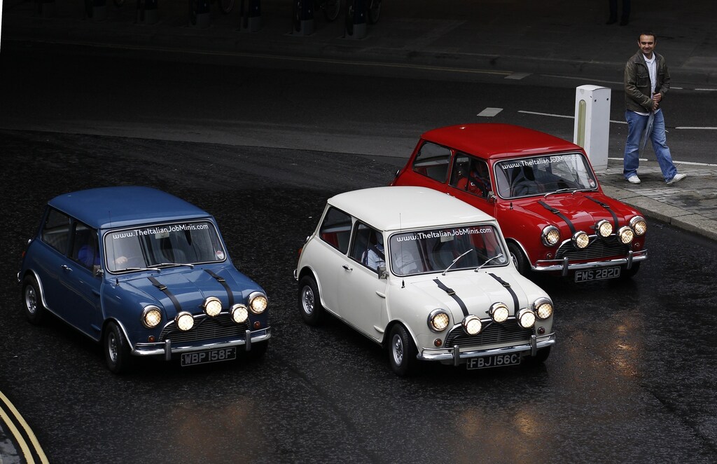 Three Mini Coopers, which were used by Paramount studios to promote the original 1969 film The Italian Job, drive through the City of London October 31, 2010. The cars will be on display at the Museum of London until November 14, 2010. REUTERS/Suzanne Plunkett (BRITAIN - Tags: SOCIETY ENTERTAINMENT) - RTXU1YQ