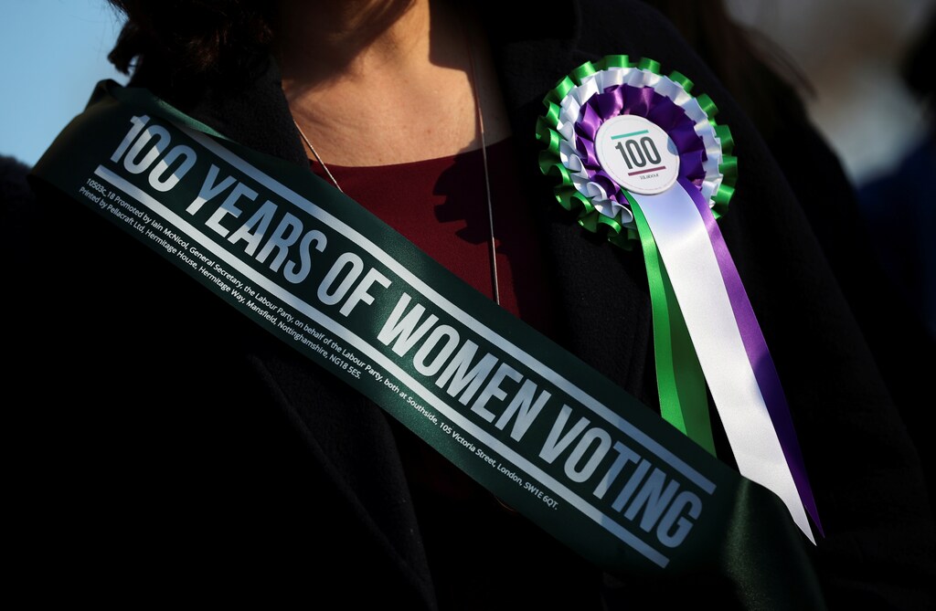 A Labour Party members of Parliament wears a rosette at an event to mark the 100th anniversary of the enfranchisment of some, but not all women, outside the Houses of Parliament in London, Britain, February international womens day un united nations world economic forum gap report women men female male girls boys teenagers teens development gender gap parity equality diversity progress change feminine masculine woman man sex biology roles dynamic balance bias androgynous politics democracy capitalism socialism fairness economics government govern administration system power voting votes elections electing faith trust electorate legislature house of commons house of lords congress senate house of representative prime minister government cabinet president executive legislative democrats republicans labour conservatives left wing right win us Australia united states new Zealand Switzerland EU European union Norway Finland Sweden united kingdom uk