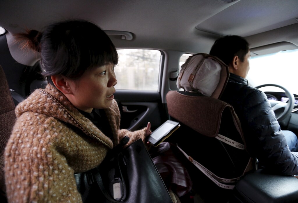 Yoko Wu instructs an Uber taxi driver en route to her office in Beijing, China, November 18, 2015. Yoko lives in the Beijing suburbs with her family and children. Uber has become her main way to beat traffic and get work done on the road. REUTERS/Kim Kyung-Hoon PICTURE 27 OF 36 - SEARCH "EARTHPRINTS BEIJING" FOR ALL IMAGES - RTX1VXHN
