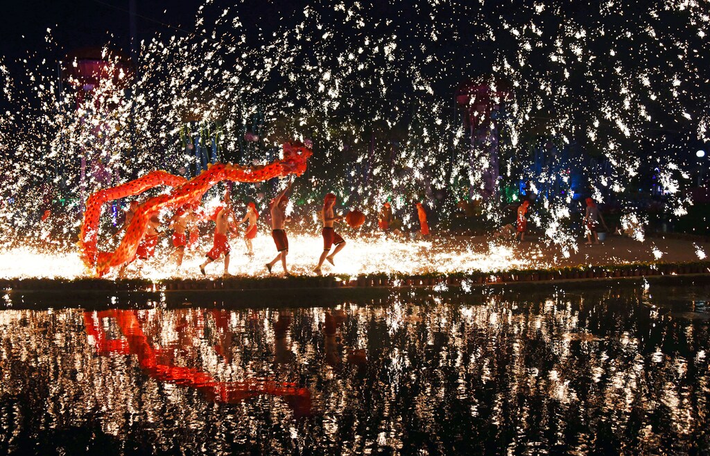 People perform a fire dragon dance under a shower of sparks from molten iron during the Chinese Lunar New Year holidays, in Wuhan, Hubei province, China, January 30, 2017. Picture taken January 30, 2017. REUTERS/Stringer ATTENTION EDITORS - THIS PICTURE WAS PROVIDED BY A THIRD PARTY. EDITORIAL USE ONLY. CHINA OUT. NO COMMERCIAL OR EDITORIAL SALES IN CHINA. TPX IMAGES OF THE DAY - RC12538FF750