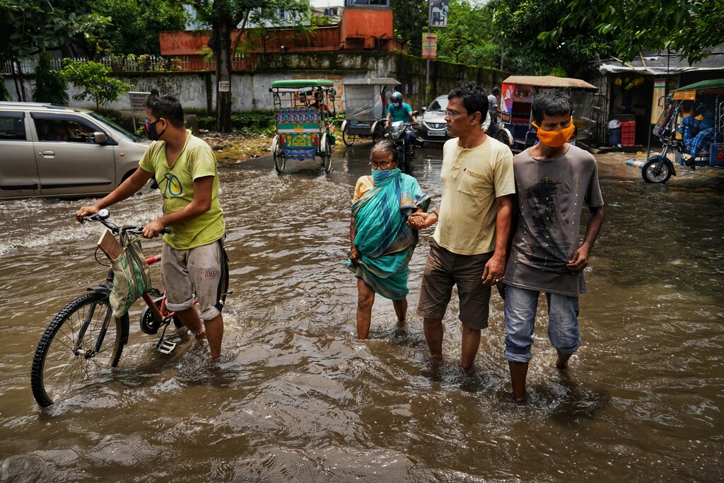 People wading through flooded streets, indicating the need for climate adaptation finance