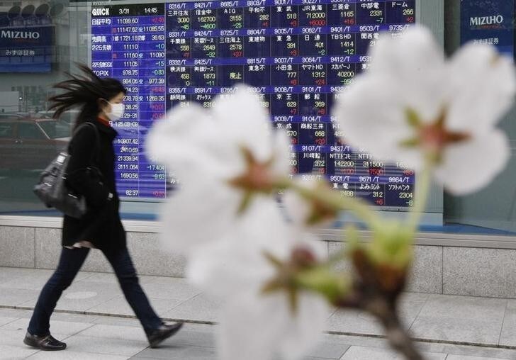 Cherry blossoms bloom in front of a stock quotation board outside a brokerage in Tokyo March 31, 2010. Japan's Nikkei average hit an 18-month intraday high before paring gains on Wednesday, the final day of the financial year, but further gains were expected in the new quarter as a global economic recovery picks up strength. REUTERS/Kim Kyung-Hoon (JAPAN - Tags: BUSINESS)