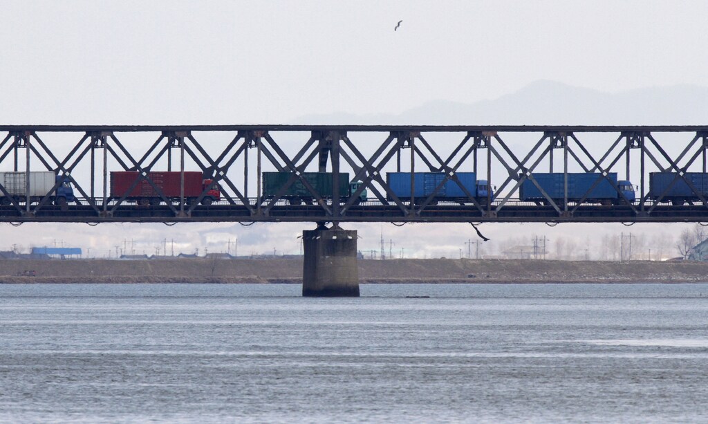 Trucks drive on the Friendship Bridge over the Yalu River which connects North Korea's Sinuiju to China's Dandong, April 11, 2013. China has stepped up checks on shipments to and from North Korea almost two months after agreeing to new U.N. sanctions that demand greater scrutiny of trade, but the flow of goods in and out of the reclusive state appears largely unaffected. Picture taken April 11, 2013. REUTERS/Jacky Chen (CHINA - Tags: BUSINESS POLITICS) - RTXZ5H5