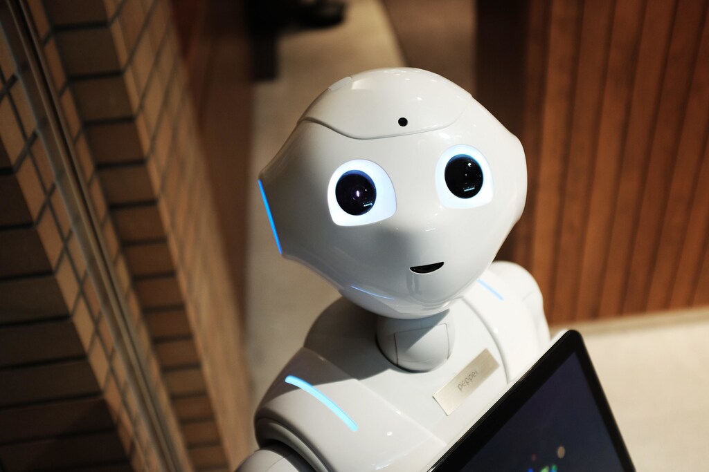 White robot near brown wall: GovTech utilises underlying technologies such as machine learning and artificial intelligence.