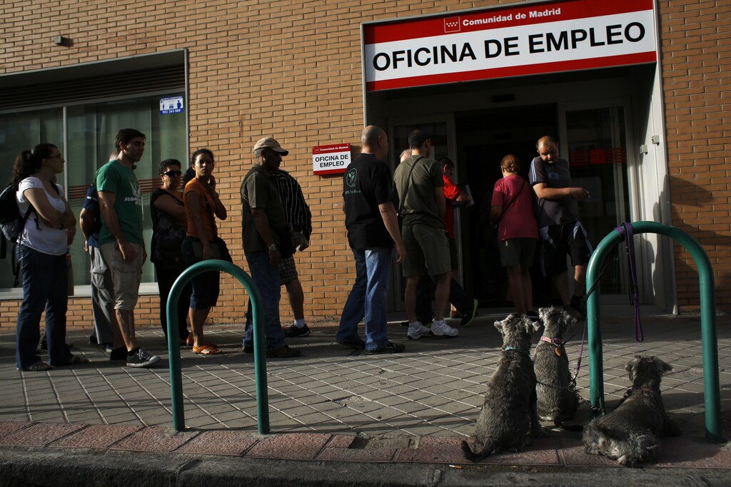 Dogs wait for their owner as people enter a government-run employment office in Madrid August 2, 2013. The number of registered jobless in Spain fell in July from a month earlier, the fifth straight month of declines, the Labour Ministry said on Friday, boosted by seasonal factors including a strong tourist season. REUTERS/Susana Vera (SPAIN - Tags: BUSINESS EMPLOYMENT SOCIETY) - RTX1281R
