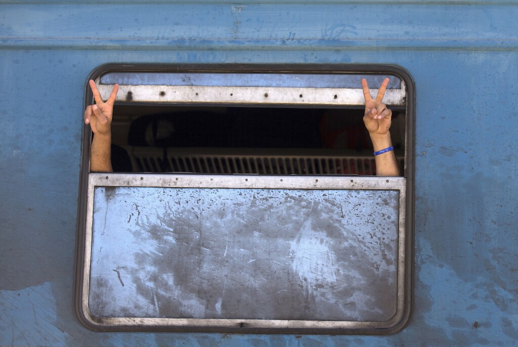 Migrants gesture after boarding a train after crossing the Macedonian-Greek border near Gevgelija, Macedonia, September 5, 2015. A record 50,000 migrants hit Greek shores in July alone and were ferried from islands unable to cope to the mainland by a government already floundering in financial crisis and keen to dispatch them promptly north into Macedonia, whence they enter Serbia and then Hungary. REUTERS/Stoyan Nenov TPX IMAGES OF THE DAY - GF10000194038