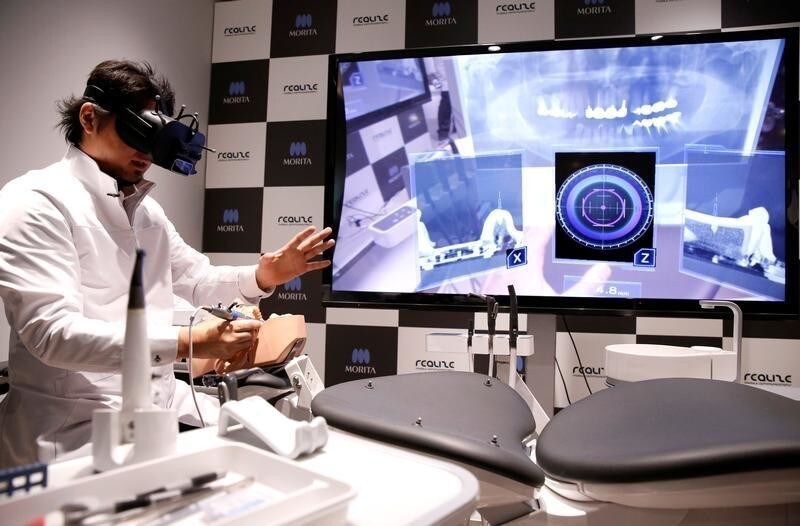 A dentist wearing a virtual reality (VR) headset, displaying X-ray photographs and other detailed information of a patient three dimensionally, demonstrates VR simulation program for dental surgeons (called WK2 Project), jointly developed by J.Morita Corp. and Realize Mobile Communications Corp., in Tokyo, Japan April 21, 2017. REUTERS/Issei Kato - RC1925B72100