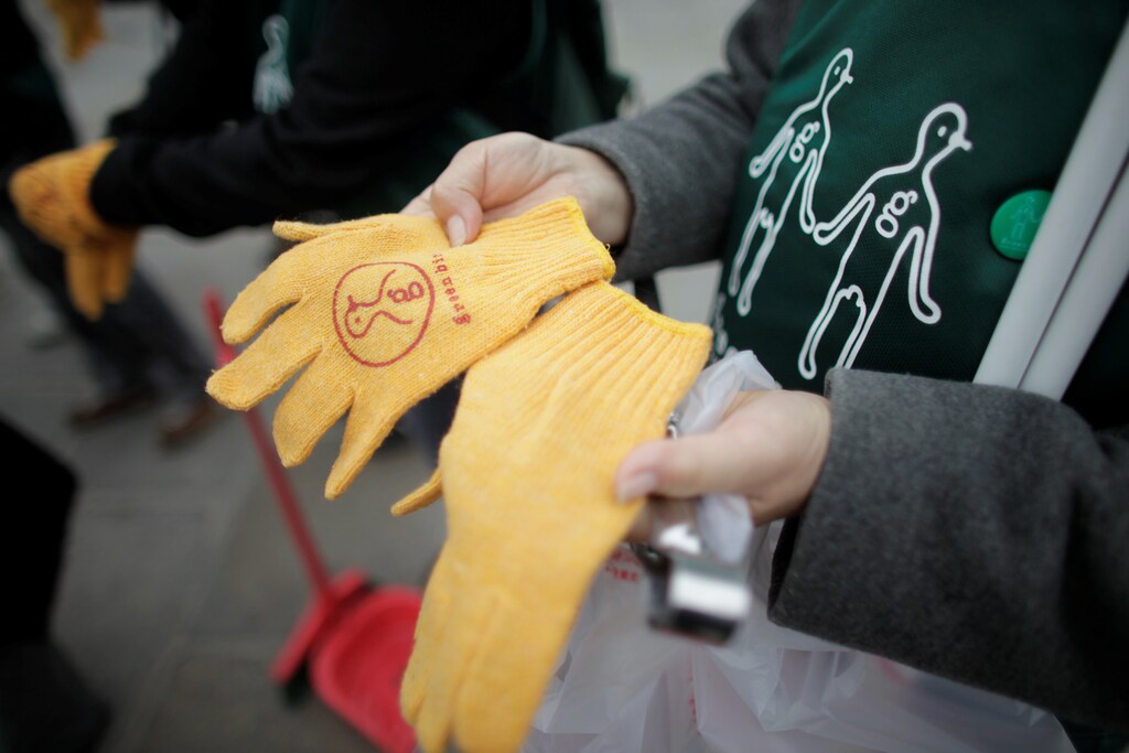 A Japanese Greenbird Paris volunteer displays her gloves before clearing litter at Place de la Concorde in Paris April 19, 2009. A group of Japanese expatriates staged a clean-up action at the famous Champs Elysees avenue on Sunday as part of a monthly campaign to make the French capital a cleaner place for the many thousands of Japanese tourists who come to one of the most visited cities in the world. REUTERS/Thomas White (FRANCE ENVIRONMENT SOCIETY) - RTXE5GW