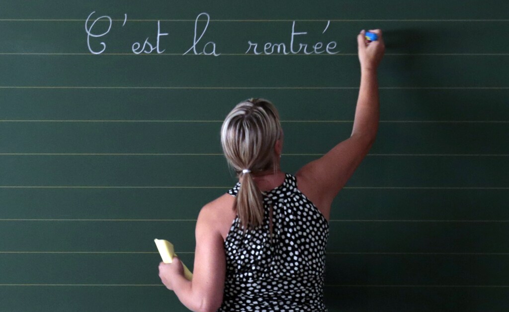 A teacher writes the phrase "Today it is the start of the new school year" on the blackboard of her classroom on the first day of the new school year at a primary school in Nice, September 3, 2013. REUTERS/Eric Gaillard (FRANCE - Tags: EDUCATION) - PM1E99314PA01