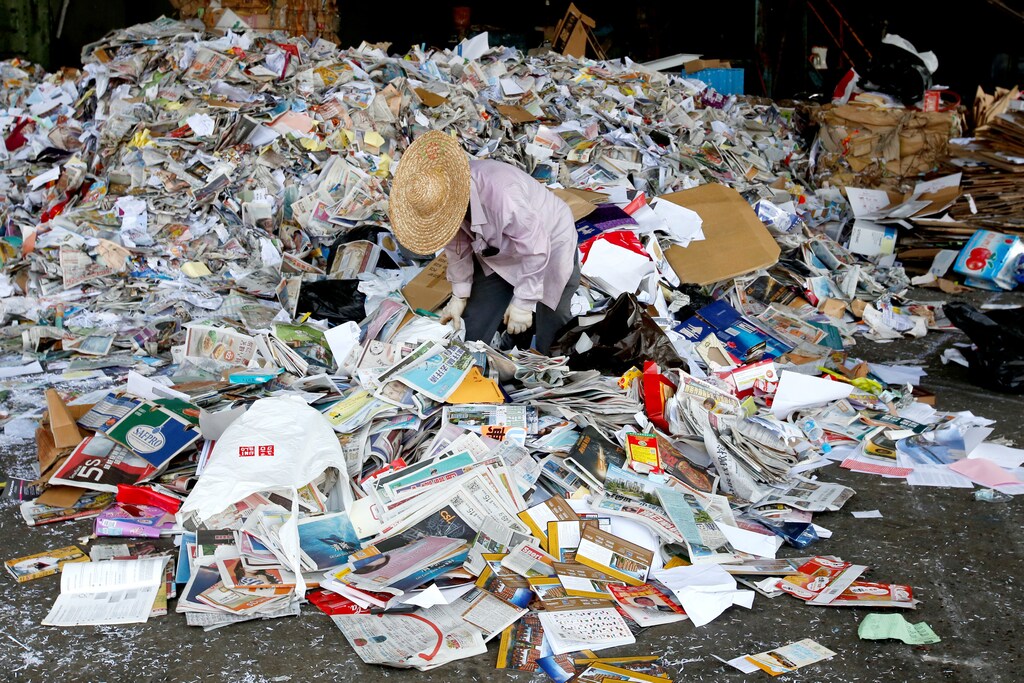 A worker picks rubbish from waste paper to be shipped to mainland China at a factory in Hong Kong, China September 19, 2017. Picture taken September 19, 2017. REUTERS/Bobby Yip - RC19063DC970