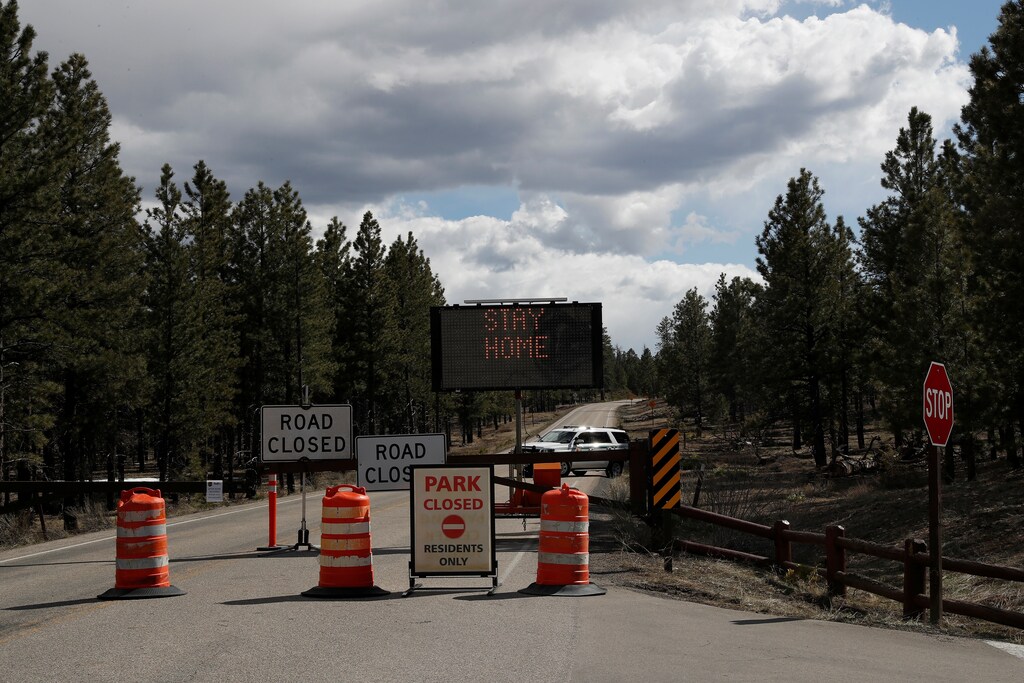 An electronic signboard reading "stay home" stands with road closed signs blocking the entrance to Bryce Canyon National Park visitors as the spread of coronavirus disease (COVID-19) continues, near Panguitch, Utah, U.S., April 11, 2020. REUTERS/Shannon Stapleton - RC2S2G94ISO9