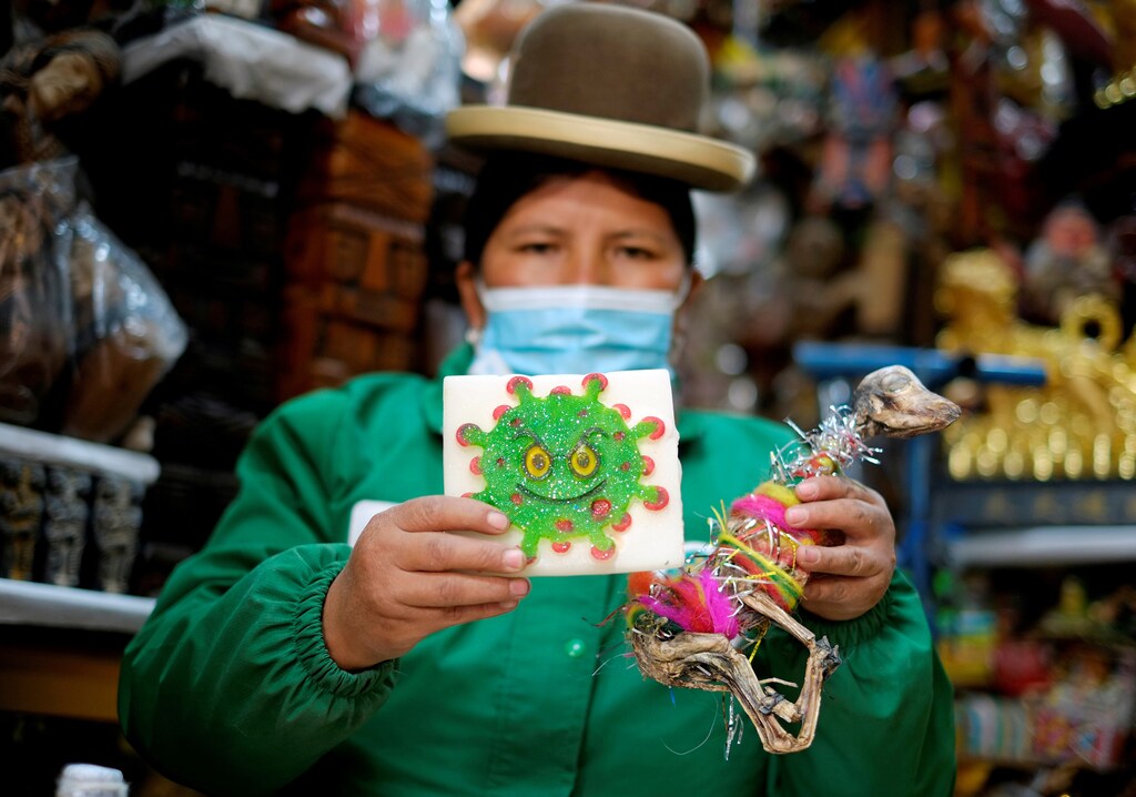 Victoria Acarapi holds a figure of the coronavirus and a llama fetus as part of an offering during the Pachamama (Mother Earth) month at the witches market, amid the outbreak of the coronavirus disease (COVID-19) in La Paz, Bolivia August 1, 2020. Picture taken August 1, 2020. REUTERS/David Mercado TPX IMAGES OF THE DAY - RC2J6I9G3XZ6