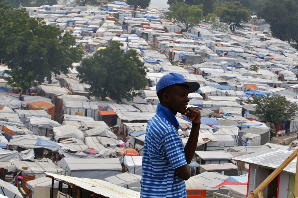 A man pauses while he walks at the Petion Ville Club golf course IDP camp in Port-au-Prince January 7, 2011. Reconstruction has barely begun in Haiti a year after its catastrophic earthquake, a leading international charity said on Wednesday in a report sharply critical of a recovery commission led by former U.S. President Bill Clinton.REUTERS/Kena Betancur (HAITI - Tags: DISASTER SOCIETY POLITICS) - RTXWB9M