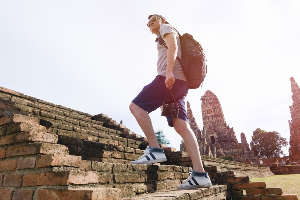 young man traveler temples Asia with lighting of sunrise, travel and recreation concept