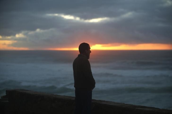 A man looks at the sea as rescue team continues its search for five missing fishermen at Macas beach, near Sintra January 14, 2015. Rescuers continued their search for the missing fishermen after their boat was shipwrecked on the beach last night, according to authorities. REUTERS/Rafael Marchante (PORTUGAL - Tags: SOCIETY DISASTER ENVIRONMENT)