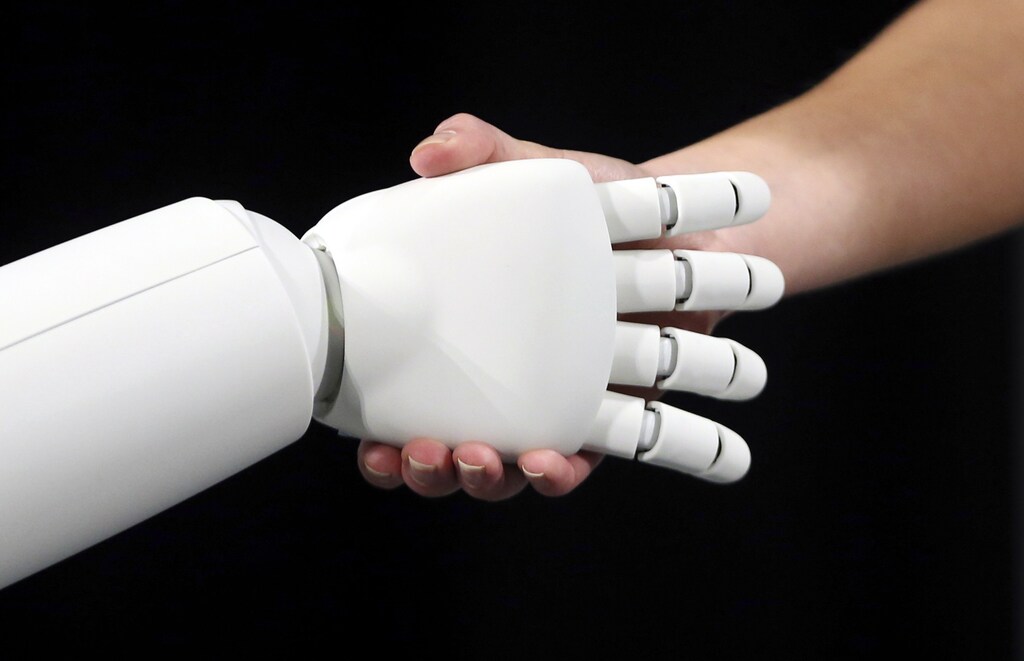 Honda's latest version of the Asimo humanoid robot shakes hands during a presentation in Zaventem near Brussels July 16, 2014. Honda introduced in Belgium an improved version of its Asimo humanoid robot that it says has enhanced intelligence and hand dexterity, and is able to run at a speed of some 9 kilometres per hour (5.6 miles per hour). REUTERS/Francois Lenoir (BELGIUM - Tags: SCIENCE TECHNOLOGY BUSINESS SOCIETY) - GM1EA7G1KHA01