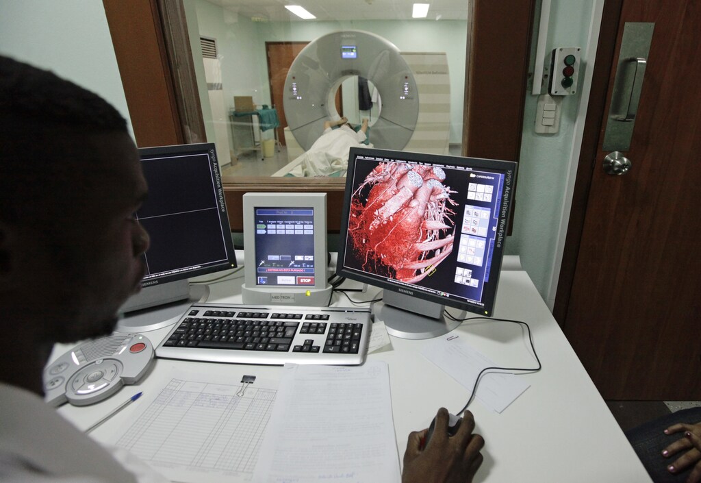 A doctor observes a screen showing a graphical representation of a heart of a woman who is lying down during a whole-body scan in the tomography section of Havana's main cardiology and heart surgery hospital October 19, 2012. Universal free education and free medical healthcare for all the population are two of the pillars of the socialist society built in Cuba since Fidel Castro's 1959 revolution. REUTERS/Desmond Boylan (CUBA - Tags: SOCIETY HEALTH) - RTR39CC0